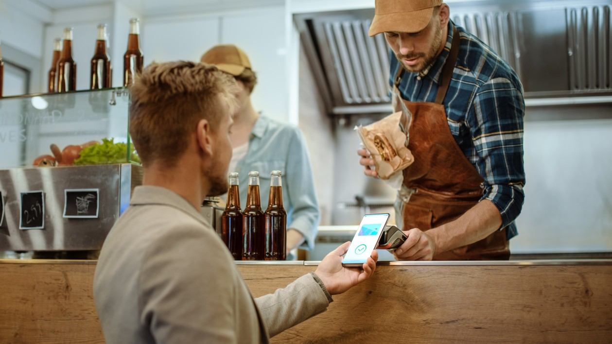 Using a smartphone for digital wallet and contactless payment at checkout.