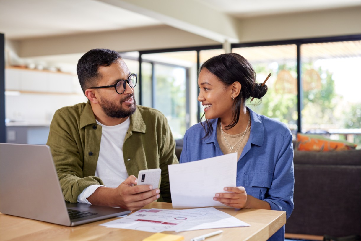 Private banker reviewing documents with a client at a conference table.