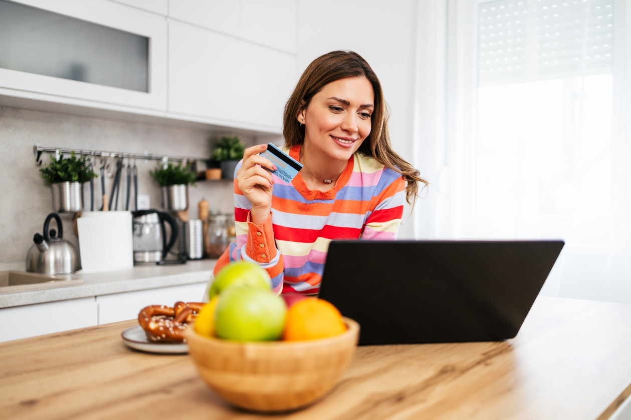 Goldspire mobile banking on phone and tablet showing accounts and card activity.