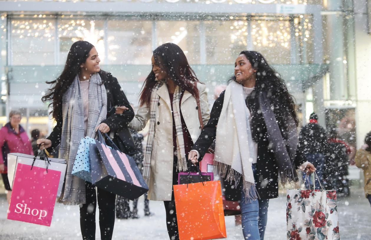 Clients shopping together with bags in a bright retail setting.