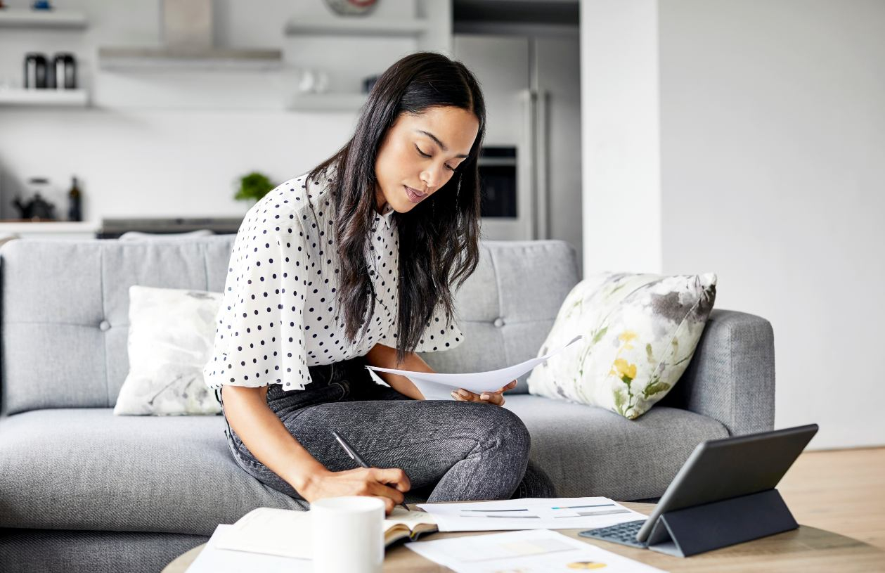 Person organizing personal finances and savings goals at a desk.