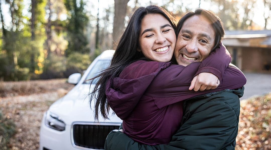 Family moment near a vehicle, suggesting trust and a major purchase decision.